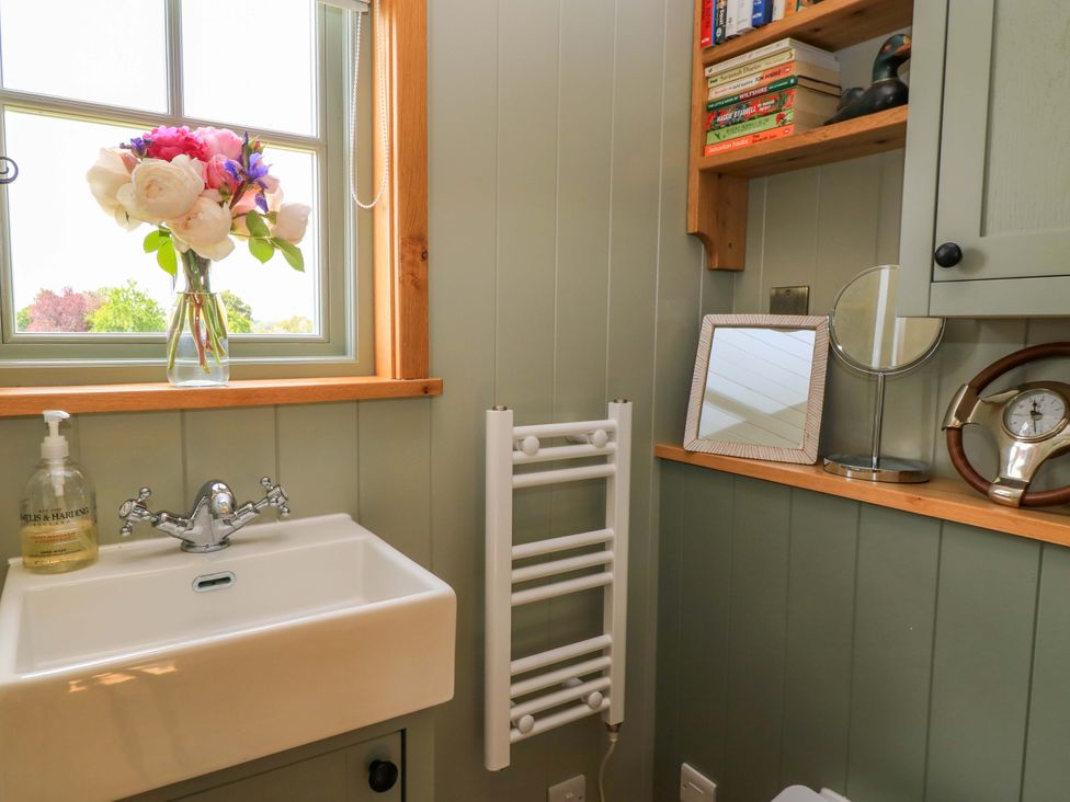 A bathroom with a sink and window at Goose Whistle Hut in Foxham