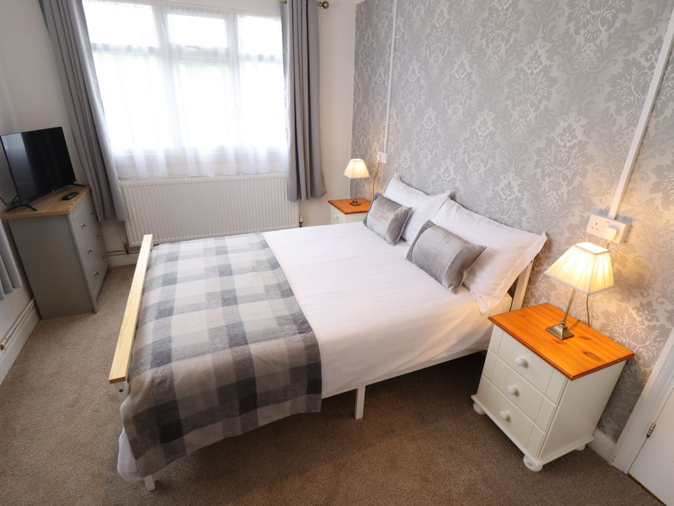 A bedroom with a bed and television at Orby Cottage in Chapel St Leonards