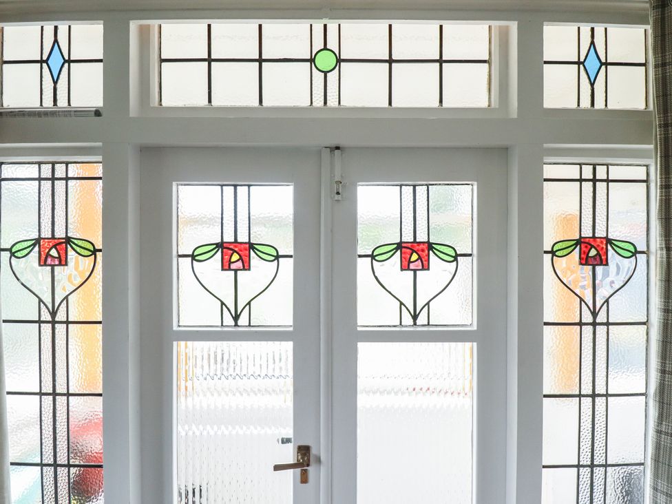 A stained glass door with decorative elements at Orby Cottage Chapel St Leonards