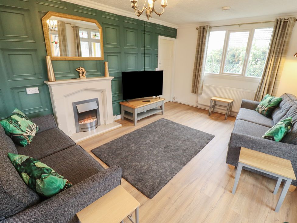 A living room with a TV and a sofa at Orby Cottage in Chapel St Leonards