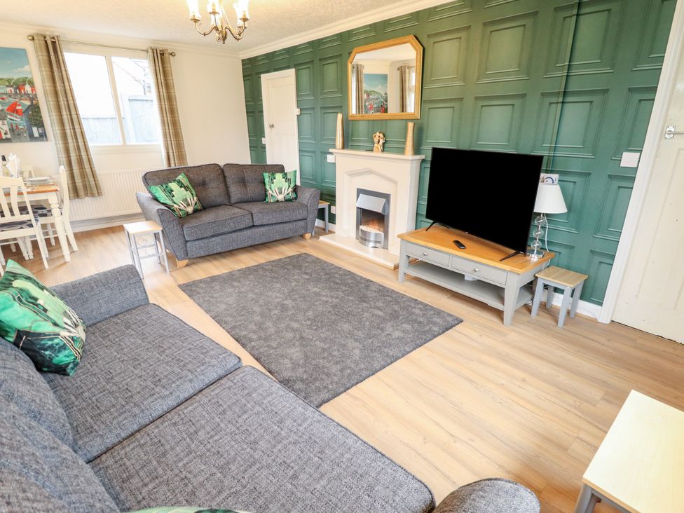 A living room with a television and sofa at Orby Cottage in Chapel St Leonards