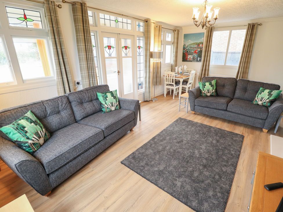 A living room with two sofas and a dining area at Orby Cottage, Chapel St Leonards