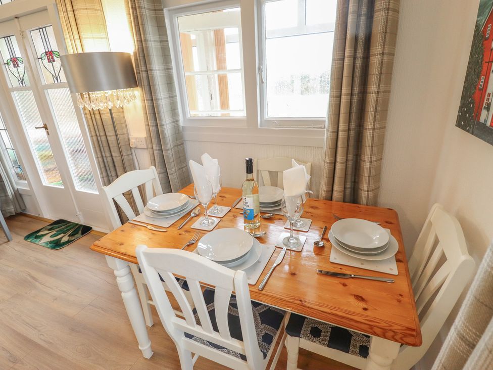 A dining room with a table set for dinner at Orby Cottage in Chapel St Leonards