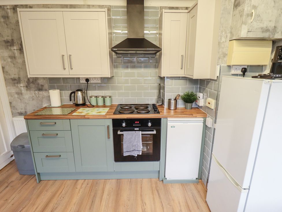 A kitchen with cabinets and appliances at Orby Cottage in Chapel St Leonards