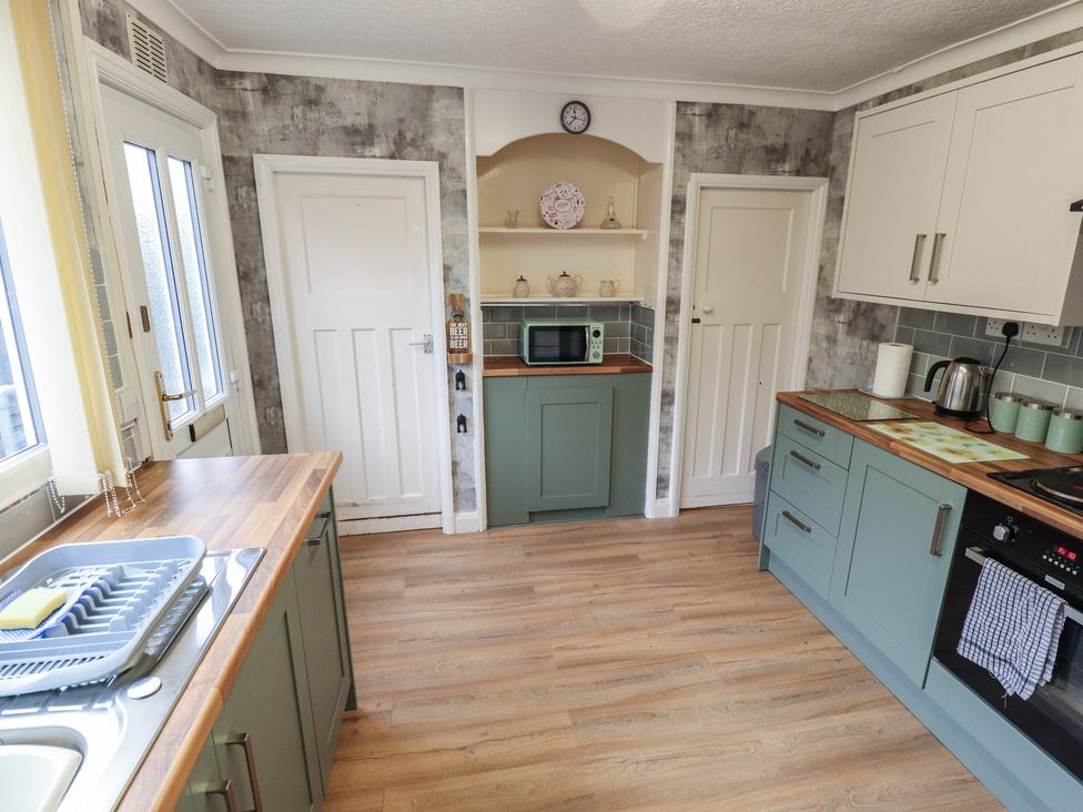A kitchen with cabinets and a microwave at Orby Cottage in Chapel St Leonards