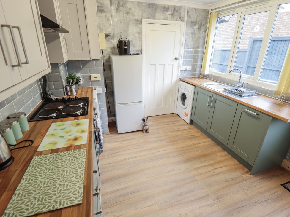 A kitchen with appliances and a counter at Orby Cottage in Chapel St Leonards
