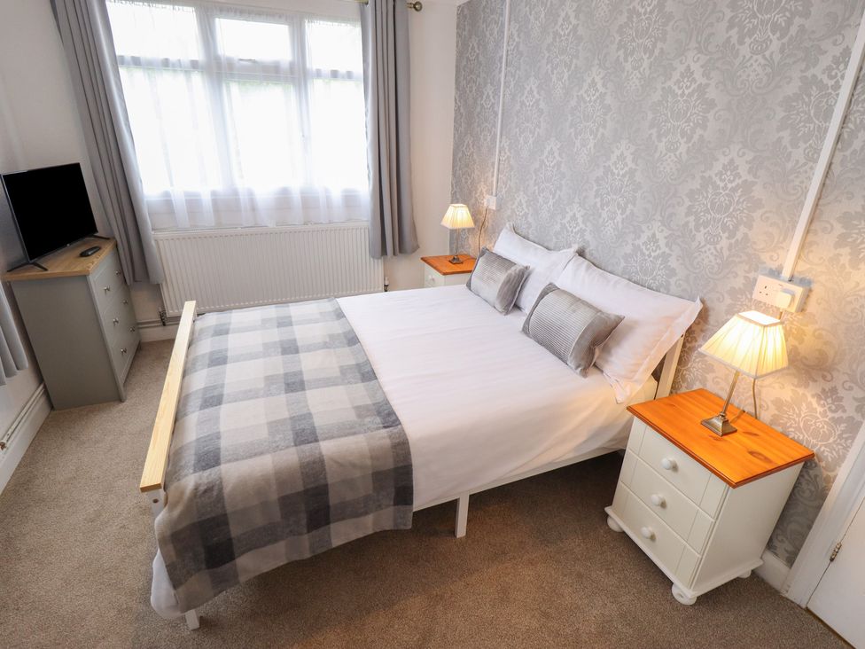 A bedroom with a double bed and furniture at Orby Cottage Chapel St Leonards