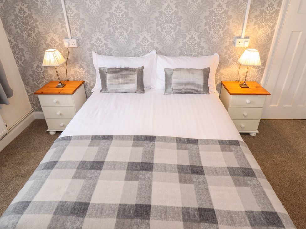 A bedroom with a bed and bedside tables at Orby Cottage Chapel St Leonards