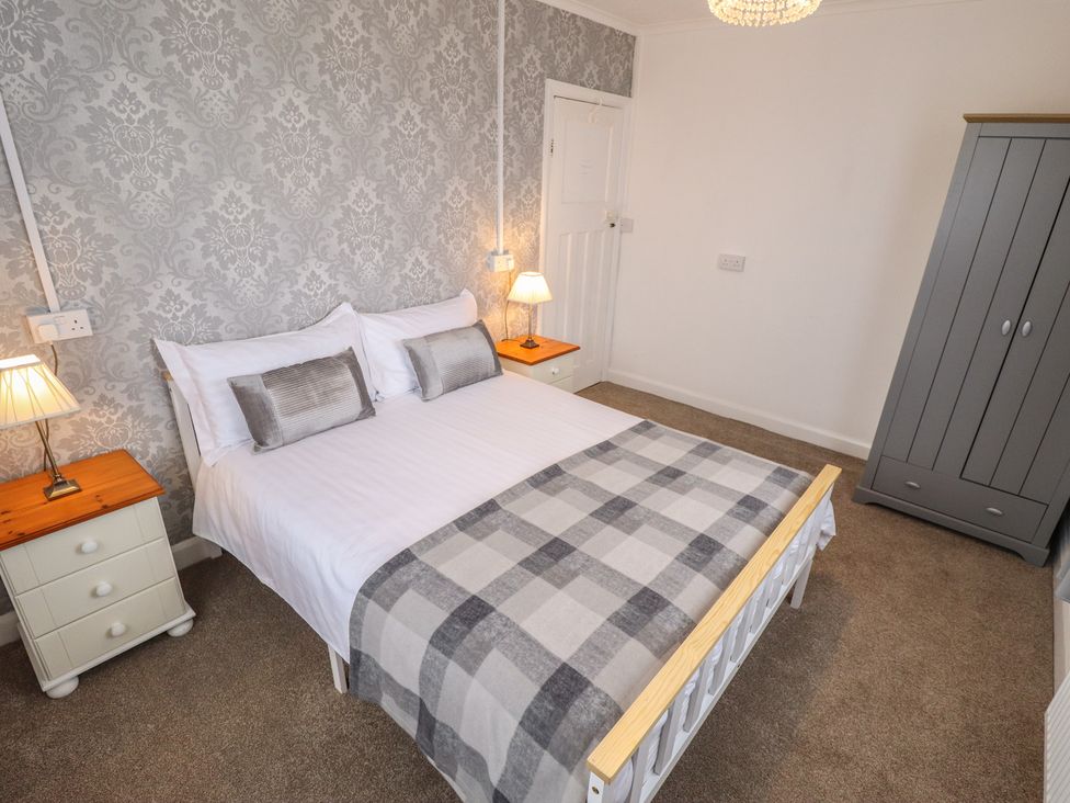 A bedroom with a bed and wardrobe at Orby Cottage in Chapel St Leonards