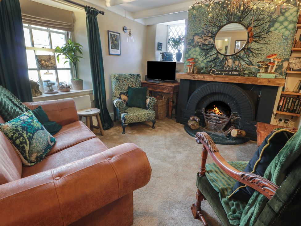 A living room with a fireplace and sofa at Rowantree Cottage in Kelso