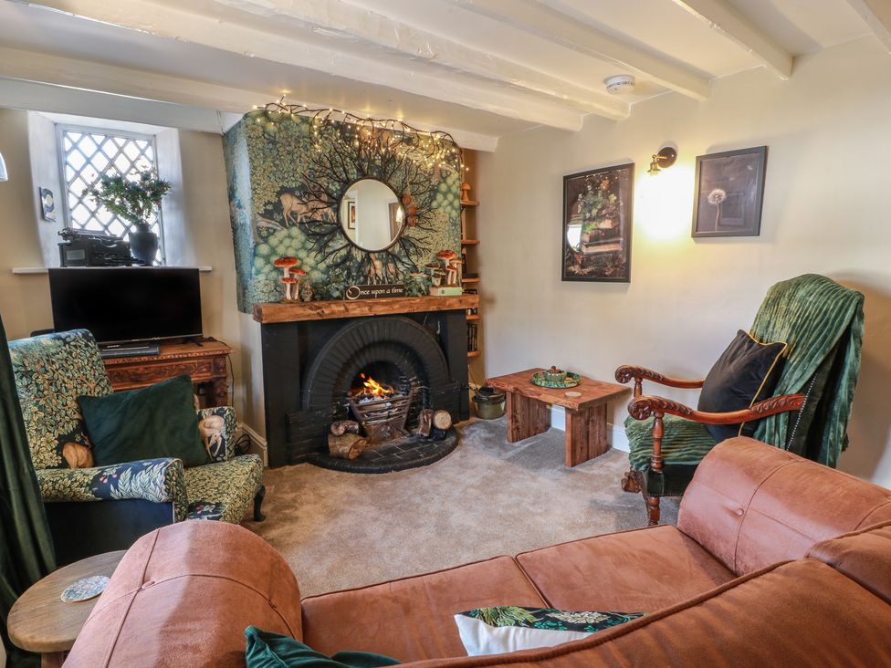 A living room with a fireplace and sofa at Rowantree Cottage in Kelso