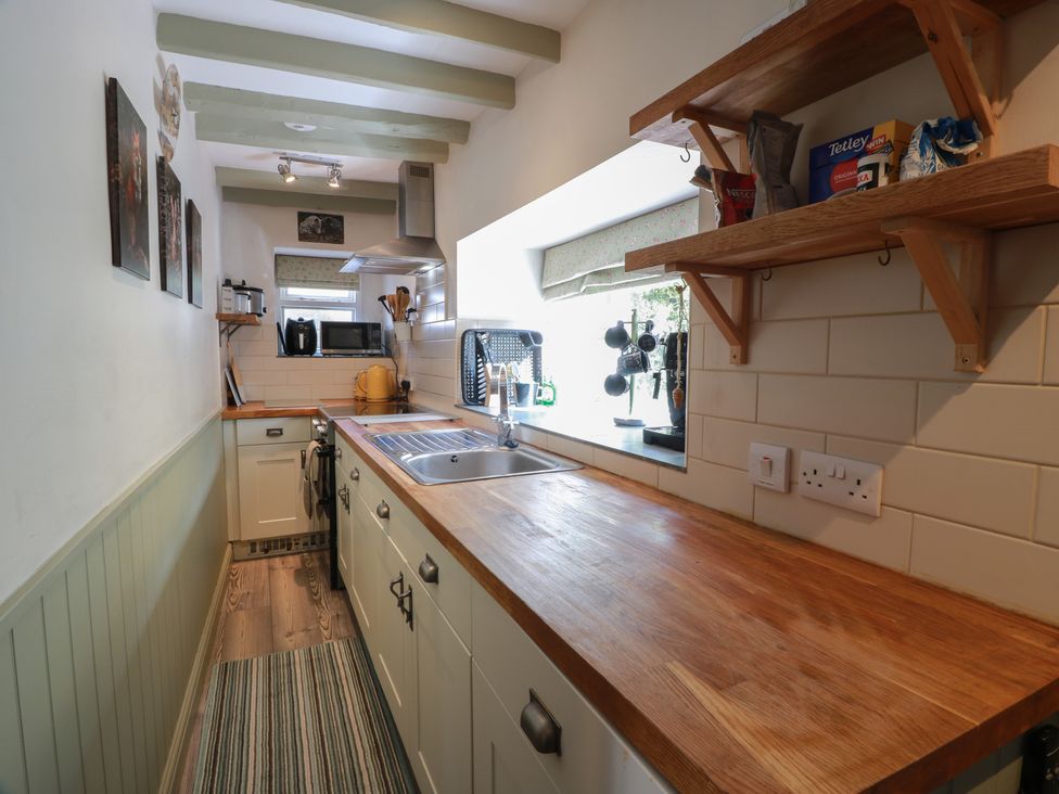 A kitchen with cabinets and a sink at Rowantree Cottage in Kelso