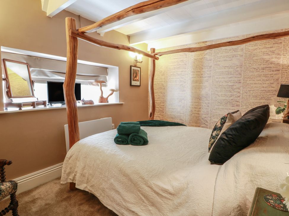A bedroom with a bed and towels at Rowantree Cottage in Kelso