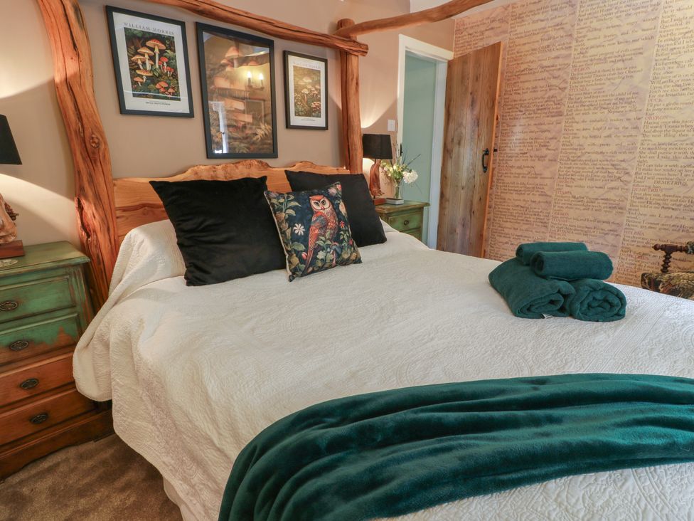 A bedroom with a bed and nightstands at Rowantree Cottage in Kelso