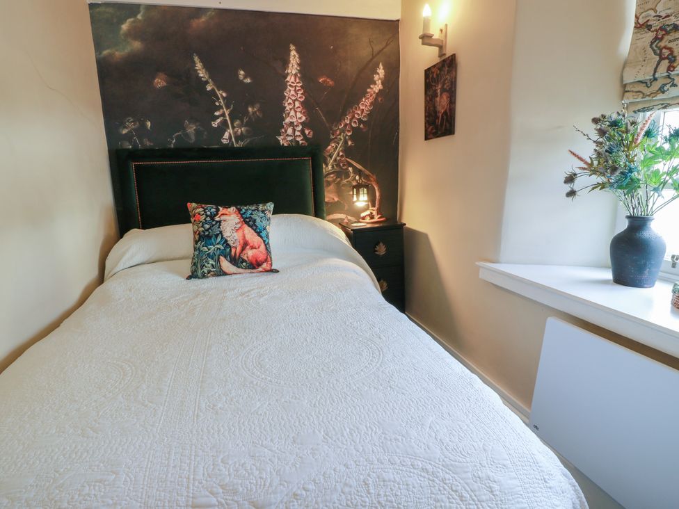 A bedroom with a bed and wall art at Rowantree Cottage in Kelso