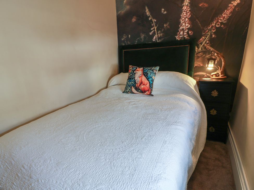 A bedroom with a bed and bedside table at Rowantree Cottage in Kelso