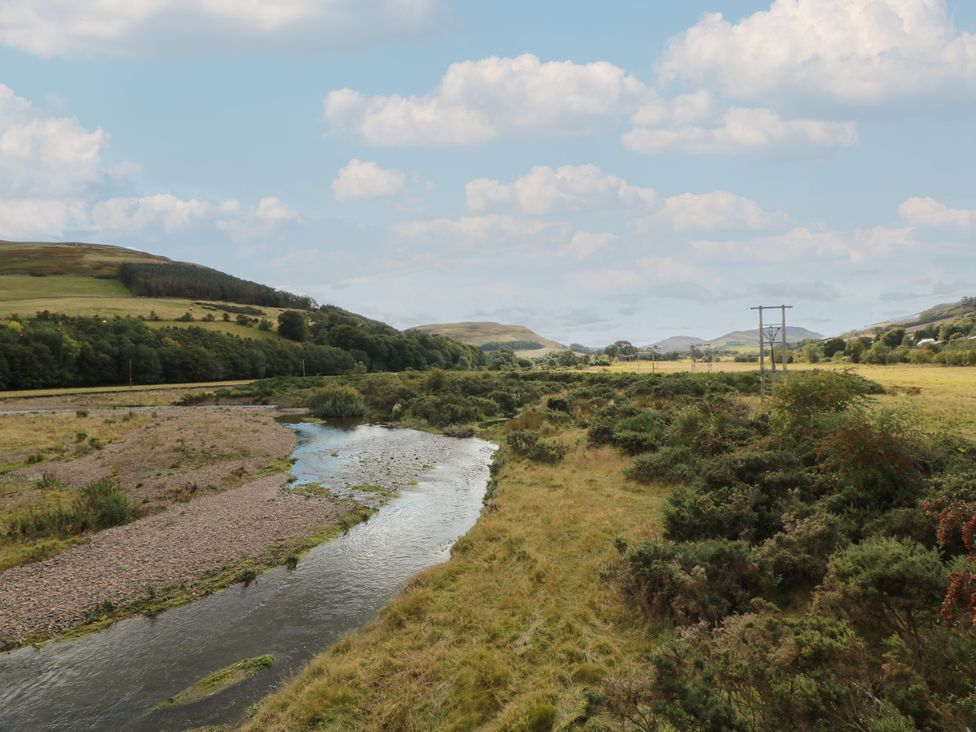 A river winding through a grassy landscape at Rowantree Cottage in Kelso