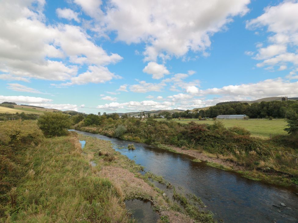 A river with trees and hills in the background at Rowantree Cottage, Kelso