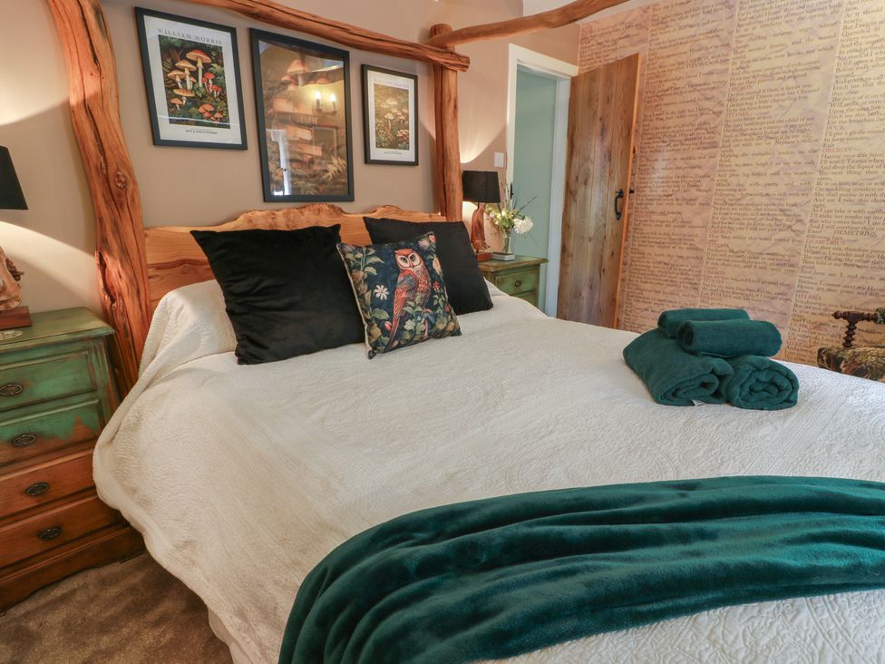 A bedroom with a bed and decorative pillows at Rowantree Cottage Town Yetholm And Kirk Yetholm