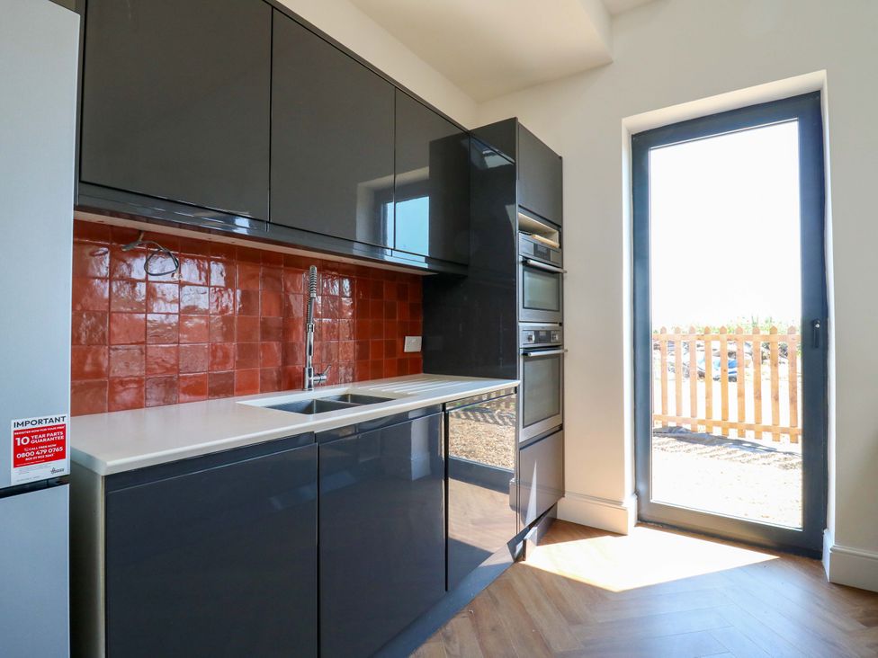 A kitchen with cabinets and sink at Little Yeat Farm in Aylesbury
