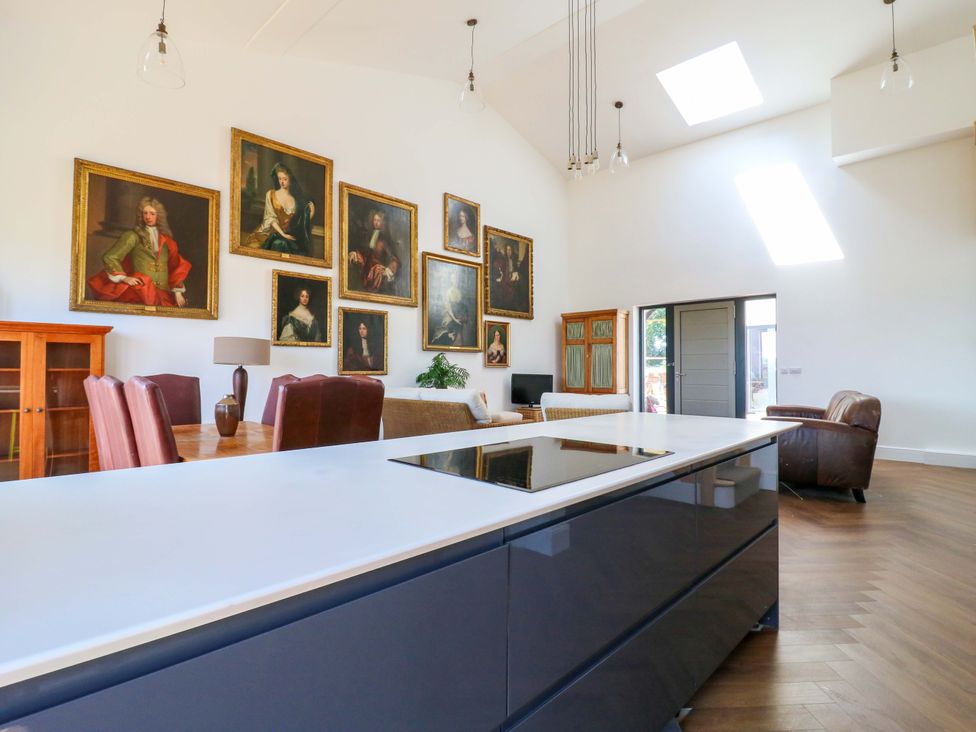 A kitchen with a dining area and paintings on the wall at Little Yeat Farm (4 Bed/2 Bath) Aylesbury