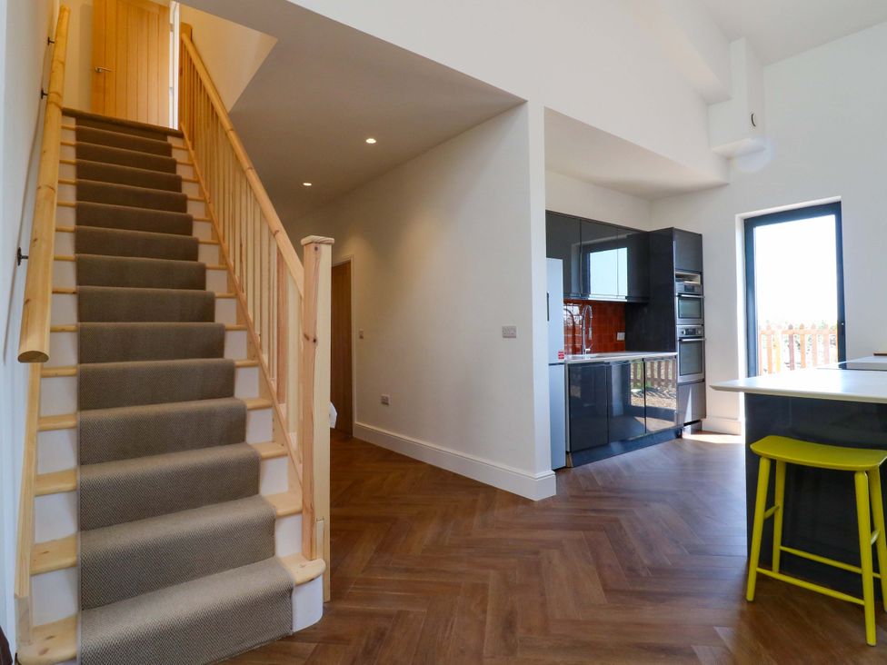 A kitchen with a staircase and modern cabinets at Little Yeat Farm (4 Bed/2 Bath) Aylesbury