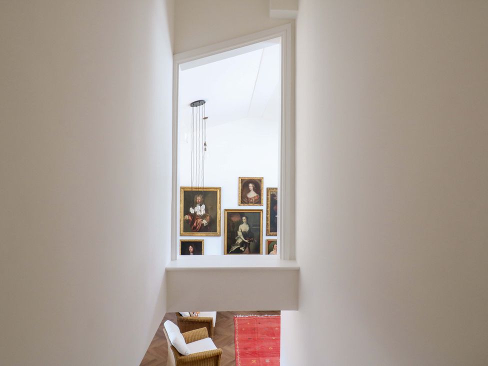 A hallway looking into a room with paintings on the wall at Little Yeat Farm (4 Bed/2 Bath) Aylesbury