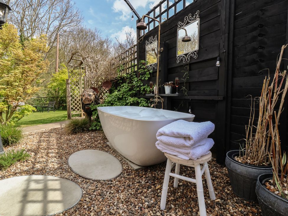 A garden with a bathtub and towels at The Corner House in Ufford near Woodbridge