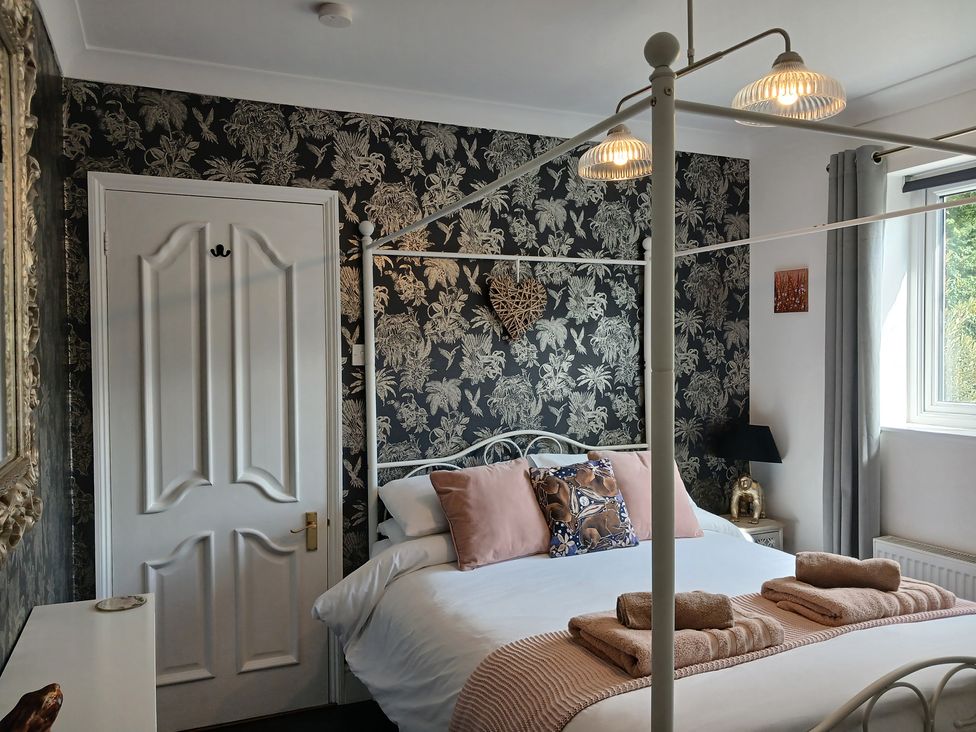 A bedroom with a bed and wall art at The Corner House in Ufford near Woodbridge