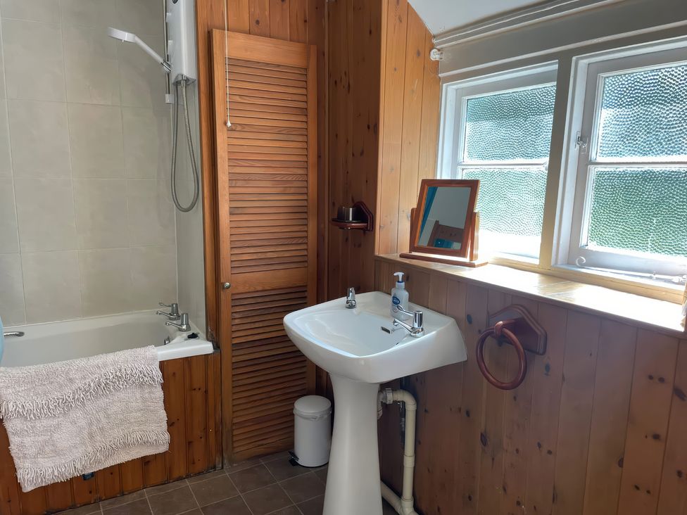 A bathroom with a bathtub and sink at Vinney Cottage in Owermoigne