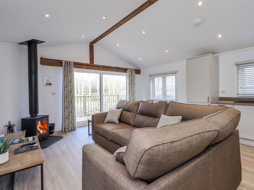 A living room with a sofa and wood stove at Lakeside Lodge near Bowland Lakes Leisure Village near Garstang