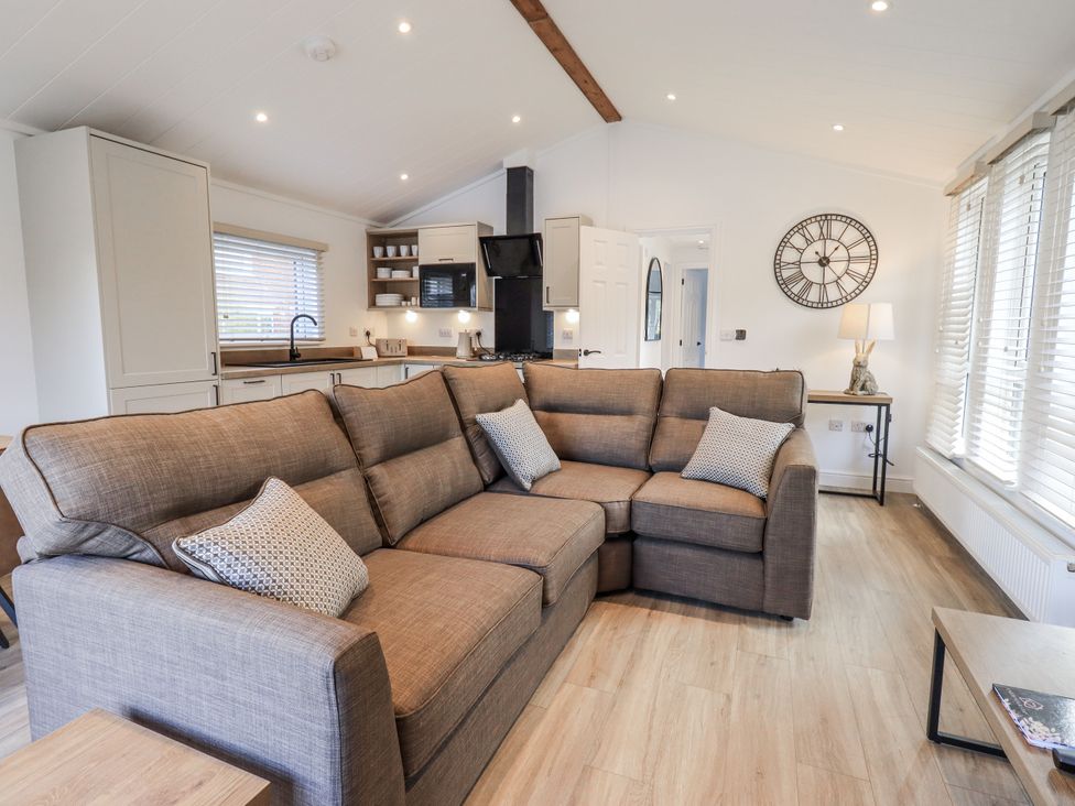 A living room with a sofa and kitchen area at Lakeside Lodge Bowland Lakes Leisure Village near Garstang