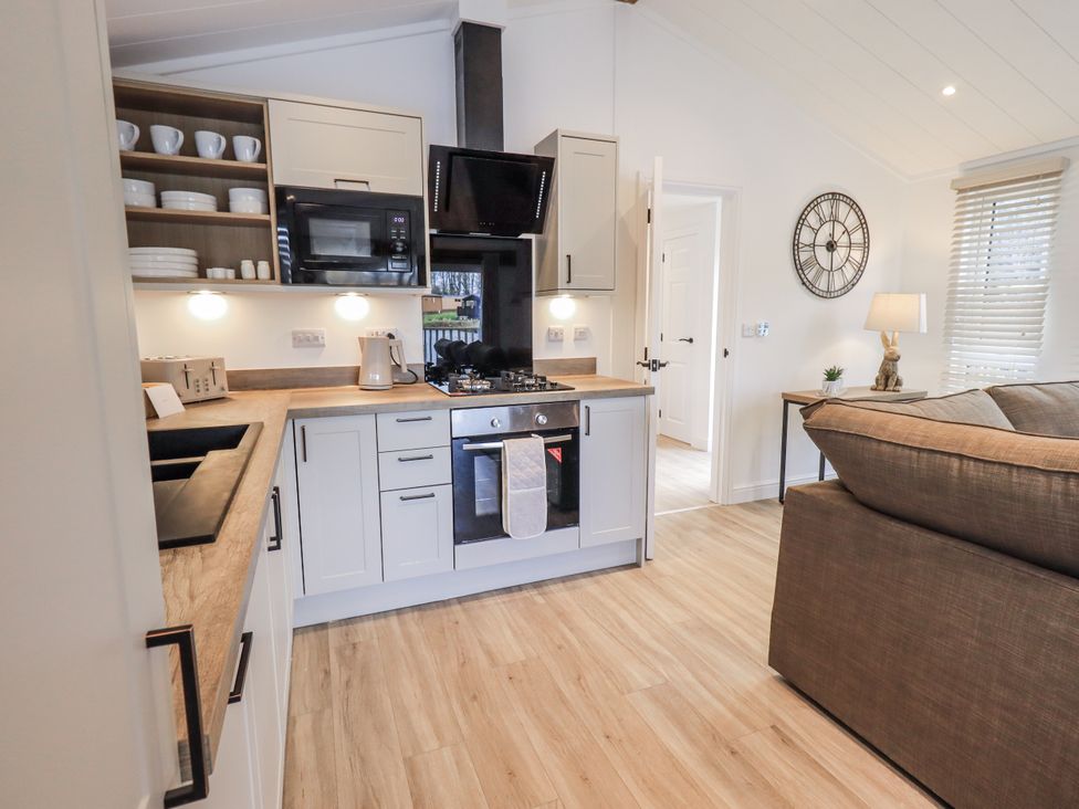A kitchen with sink stove and microwave at Lakeside Lodge Bowland Lakes Leisure Village near Garstang