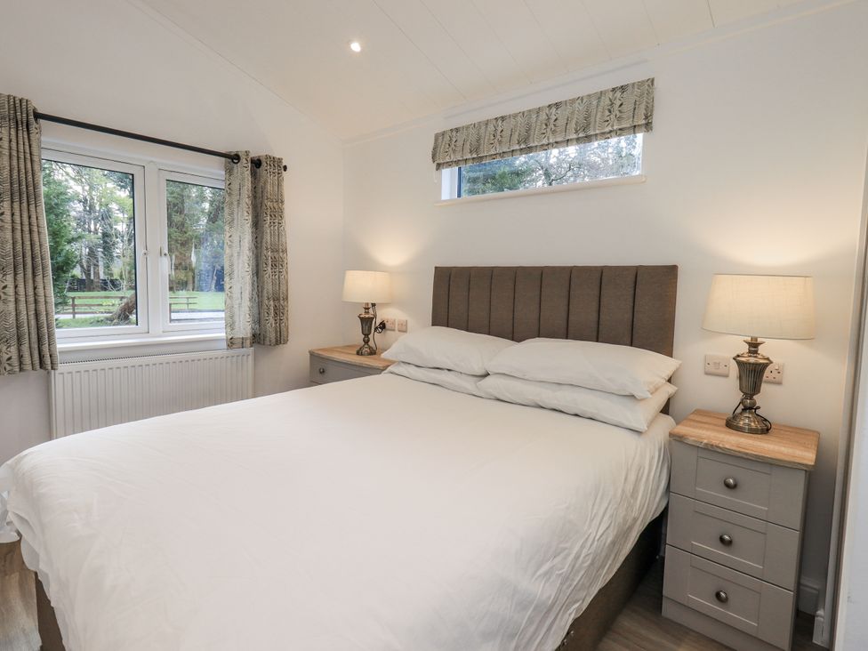 A bedroom with a bed and nightstand at Lakeside Lodge near Bowland Lakes Leisure Village