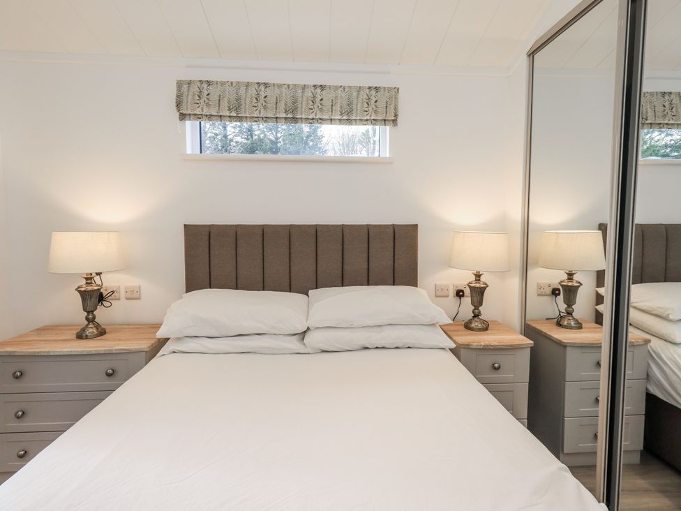 A bedroom with a bed and nightstands at Lakeside Lodge Bowland Lakes Leisure Village near Garstang