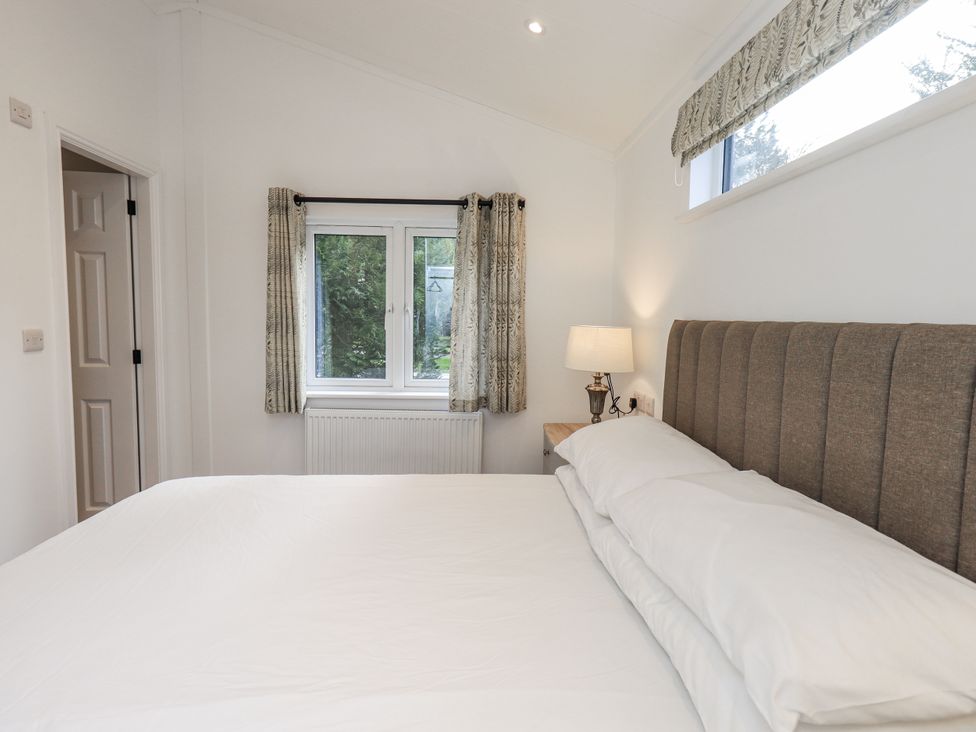 A bedroom with a bed and lamp at Lakeside Lodge near Bowland Lakes Leisure Village