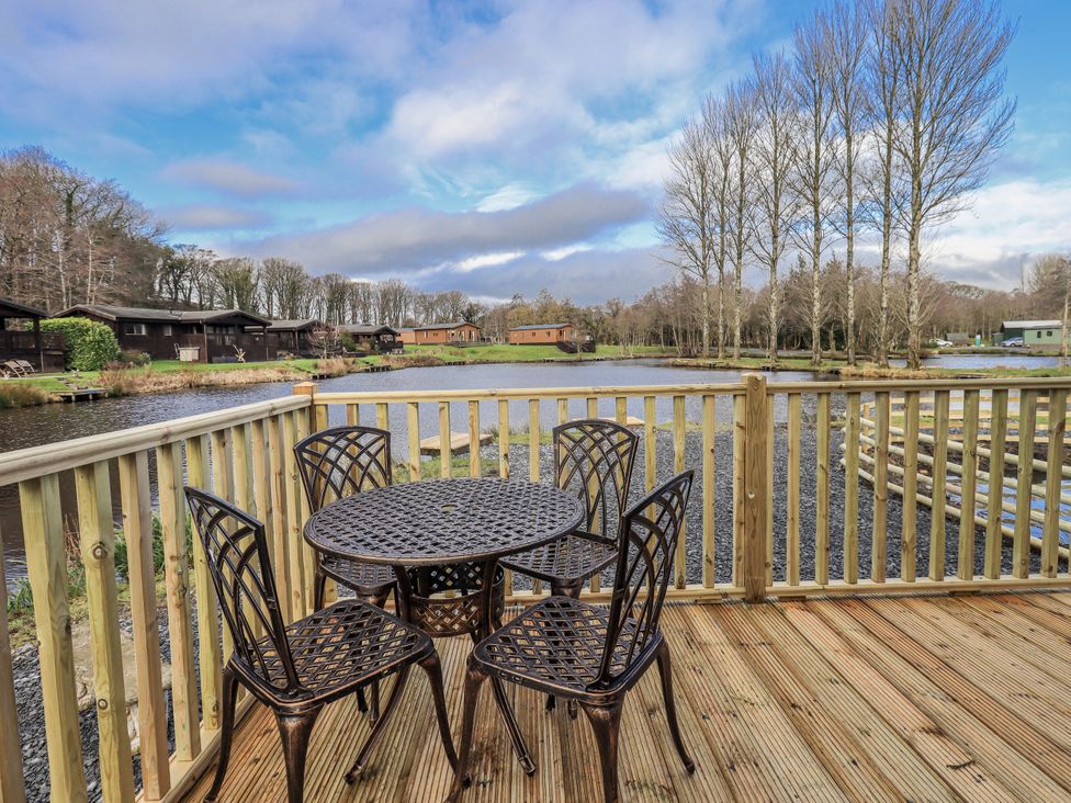 An outdoor seating area by a lake at Lakeside Lodge near Bowland Lakes Leisure Village
