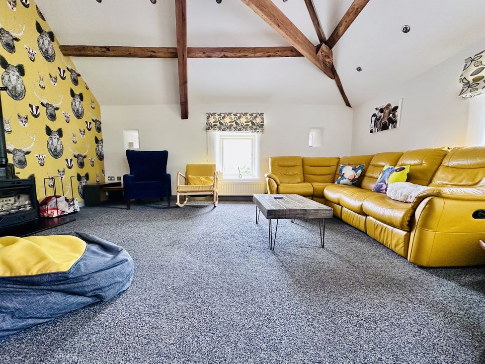 A living room with a yellow sofa and armchair at Parlour Barn in Leek