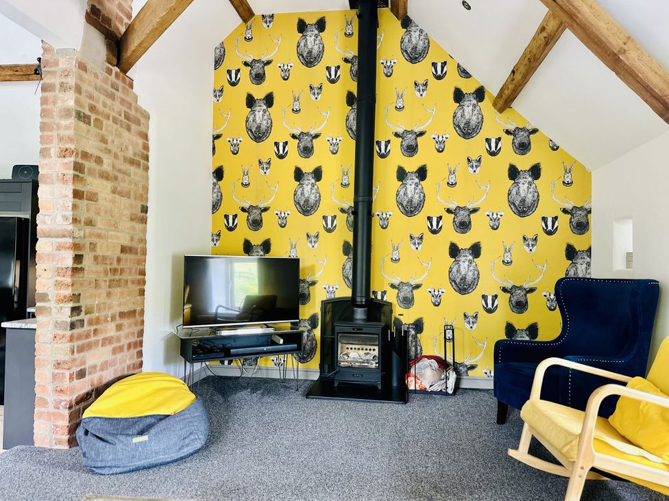 A living room with a television and fireplace at Parlour Barn in Leek