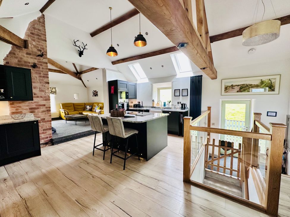 A kitchen with a central island and seating at Parlour Barn in Leek