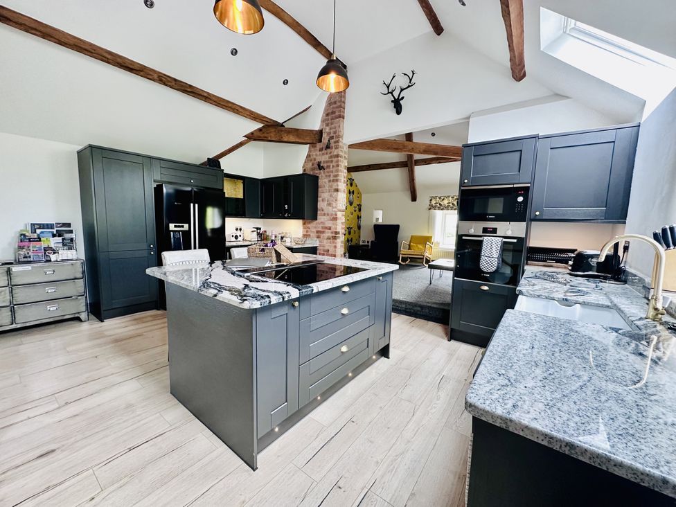 A kitchen with an island and appliances at Parlour Barn in Leek