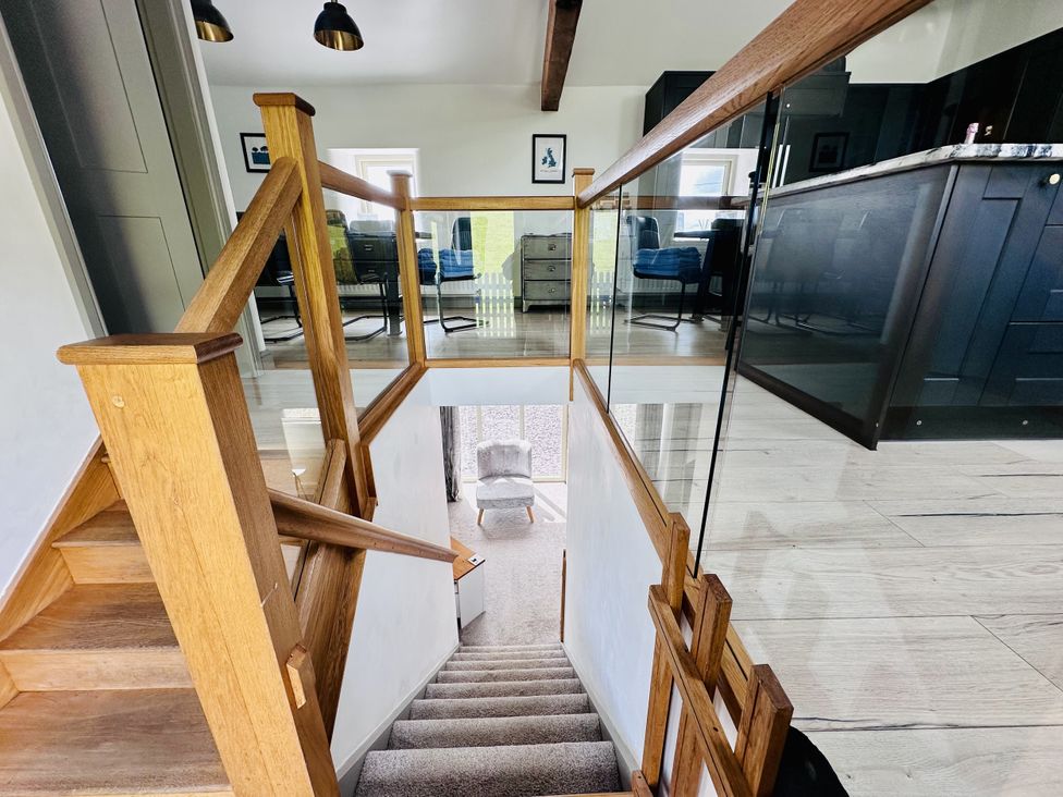 A staircase with railing and door at Parlour Barn in Leek
