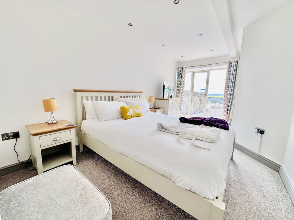 A bedroom with a bed and nightstand at Parlour Barn in Leek