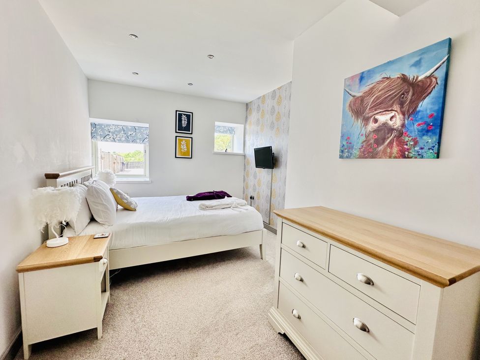 A bedroom with a bed and dresser at Parlour Barn in Leek
