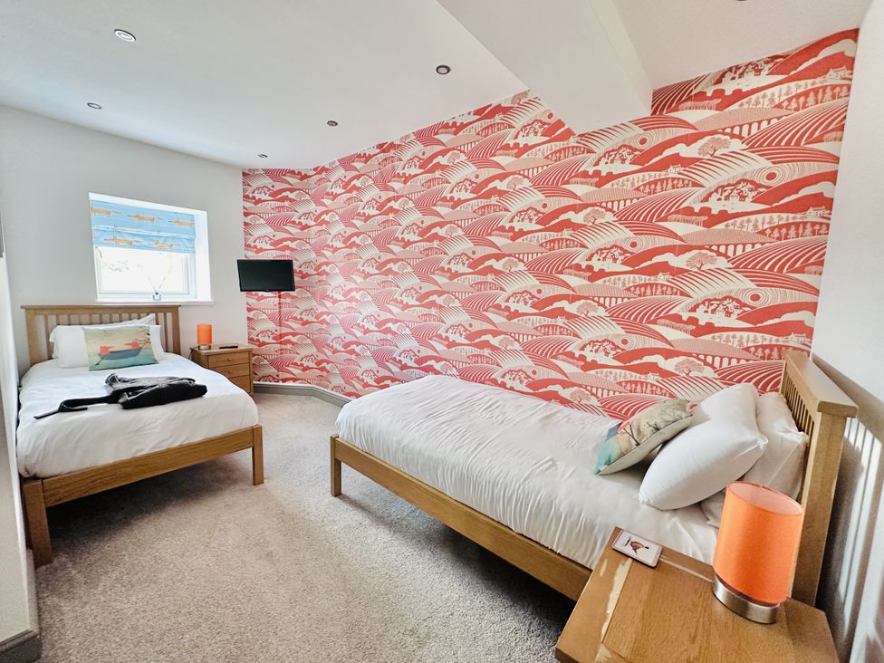 A bedroom with two beds and a television at Parlour Barn in Leek