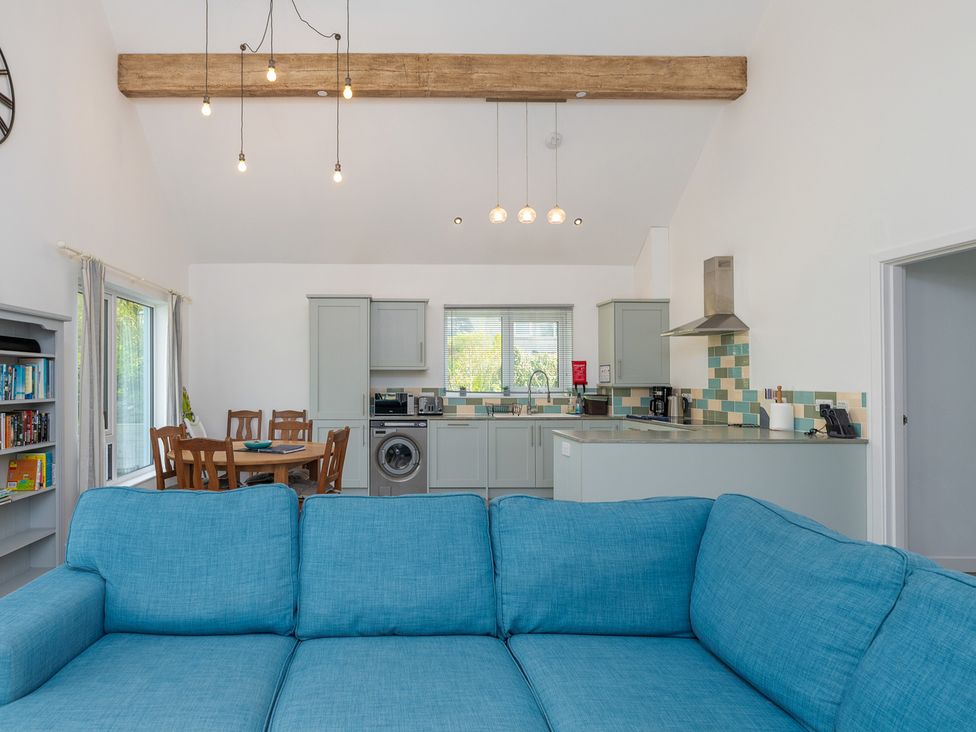 A living room with a sofa and kitchen in Moranedd Bach in Holyhead