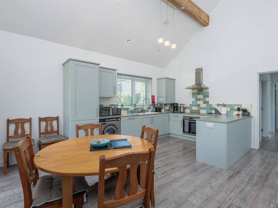 A kitchen with a table and chairs at Moranedd Bach in Holyhead