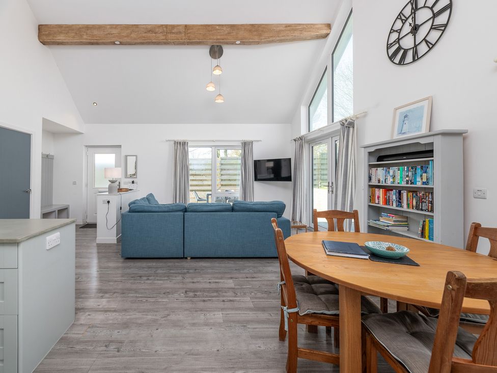A living room with a sofa and dining table at Moranedd Bach in Holyhead