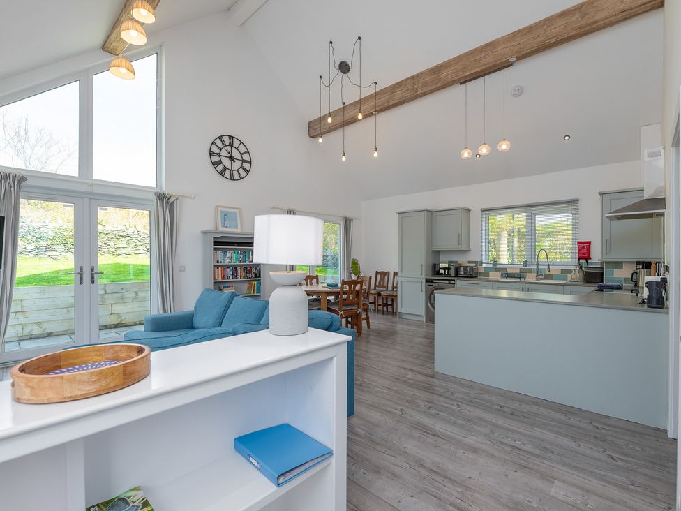A living room with a kitchen area and seating at Moranedd Bach in Holyhead