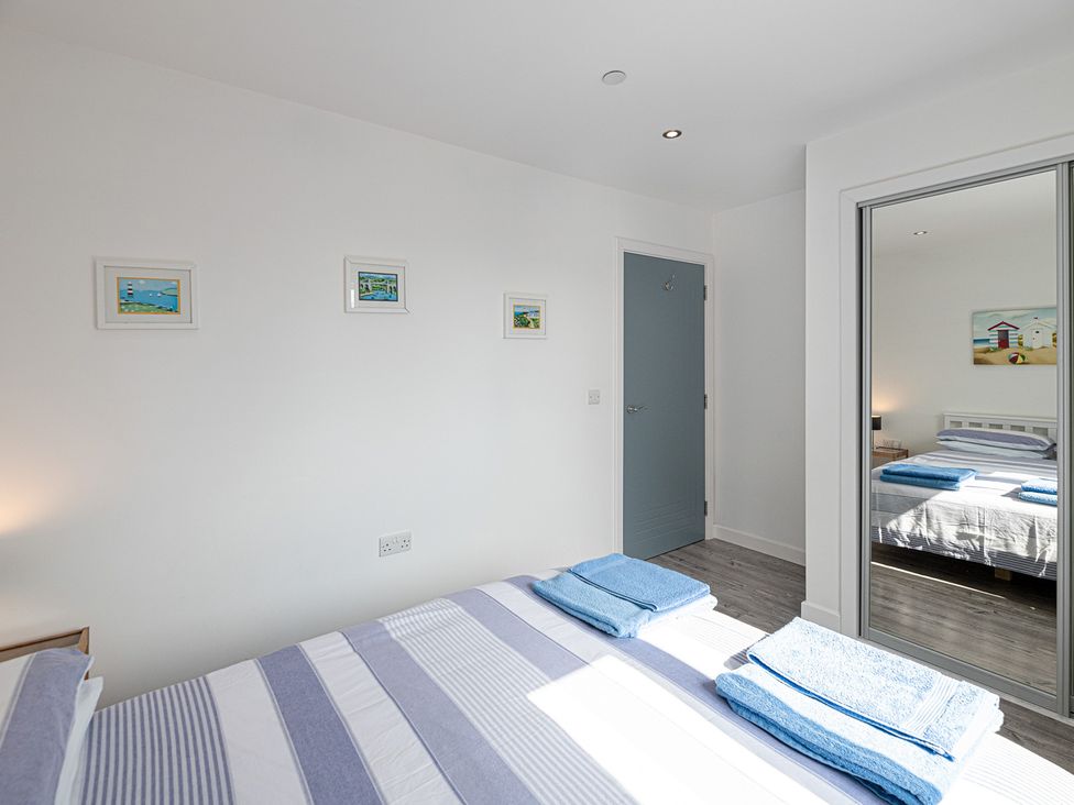 A bedroom with beds and towels at Moranedd Bach in Holyhead